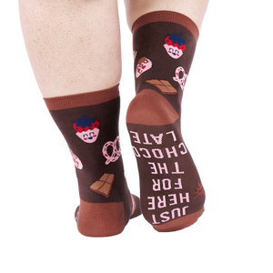 View from behind of person wearing chocolate pattern socks. The sole of one sock says 