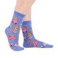 Person's feet wearing periwinkle crew socks with a guinea pig workout pattern, viewed from the side on white.
