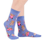 Person's feet wearing periwinkle crew socks with a guinea pig workout pattern, viewed from the side on white.