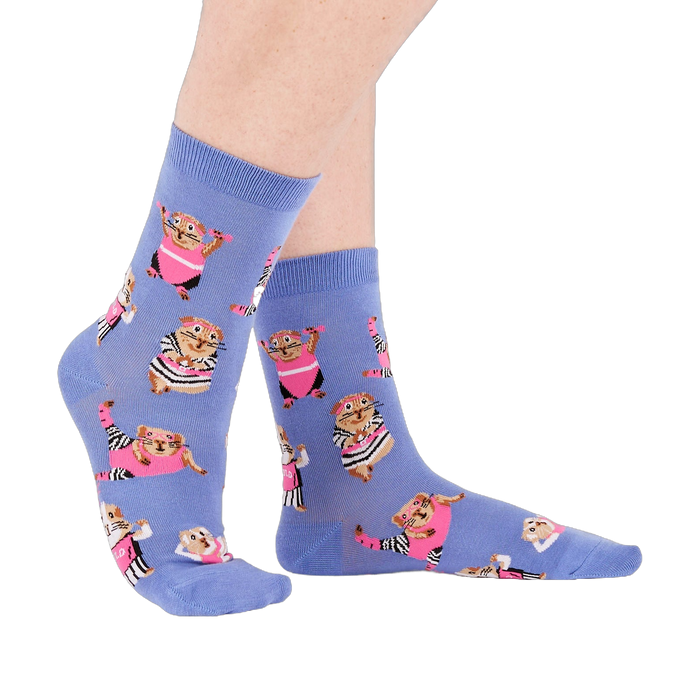 Person's feet wearing periwinkle crew socks with a guinea pig workout pattern, viewed from the side on white.
