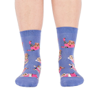 Person's feet wearing periwinkle crew socks with a guinea pig workout pattern, viewed from the front on white.