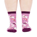 Person wearing the lavender 'Snuggle Bunny' crew socks, viewed from the front, showing leg and foot.