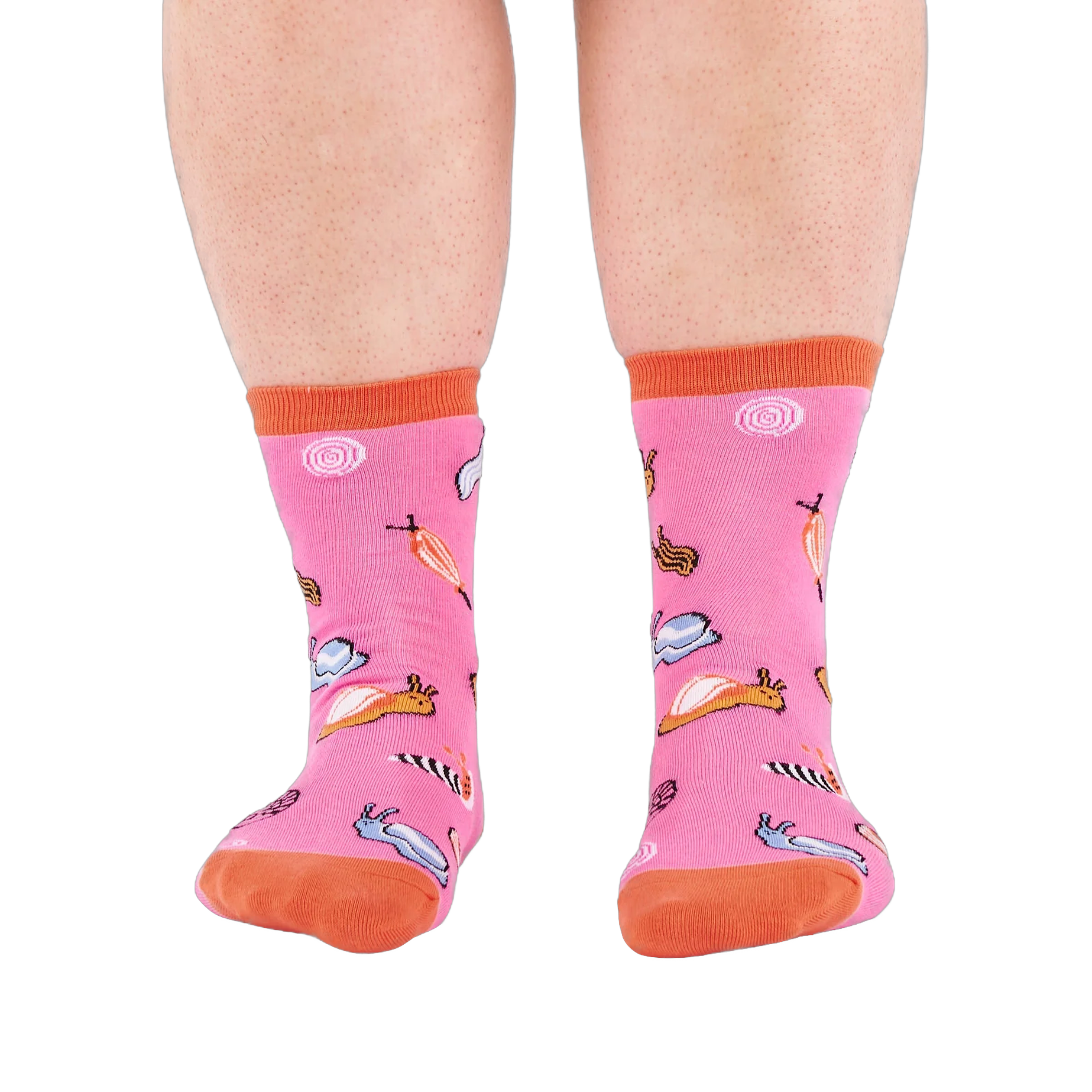 Front view of someone's lower legs wearing pink socks with colorful jelly candy snails, candy swirls, and an orange cuff.