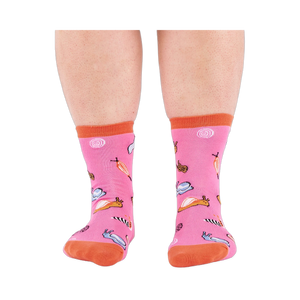 Front view of someone's lower legs wearing pink socks with colorful jelly candy snails, candy swirls, and an orange cuff.