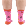 Back view of someone's calves wearing pink socks with jelly candy snails, candy swirls, and contrasting orange heels.