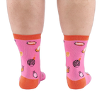 Back view of someone's calves wearing pink socks with jelly candy snails, candy swirls, and contrasting orange heels.
