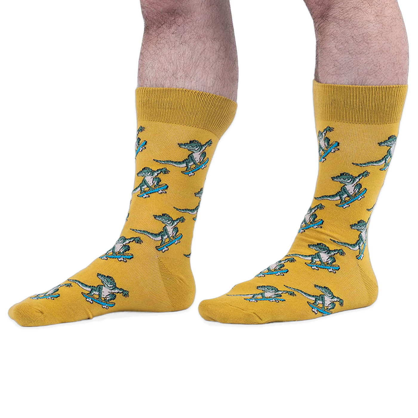 Someone wearing yellow crew socks with a green skateboarding alligator pattern, set against a black background.