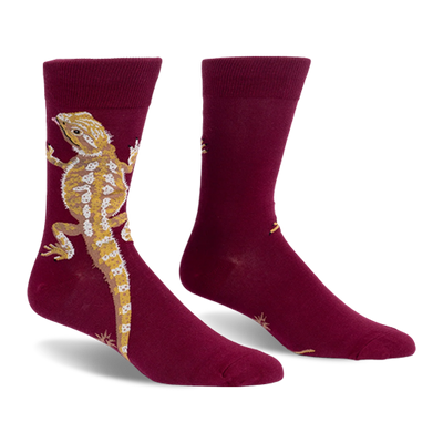 Burgundy crew socks with a large tan and yellow bearded dragon climbing up the outer side and a long tail pointing down.