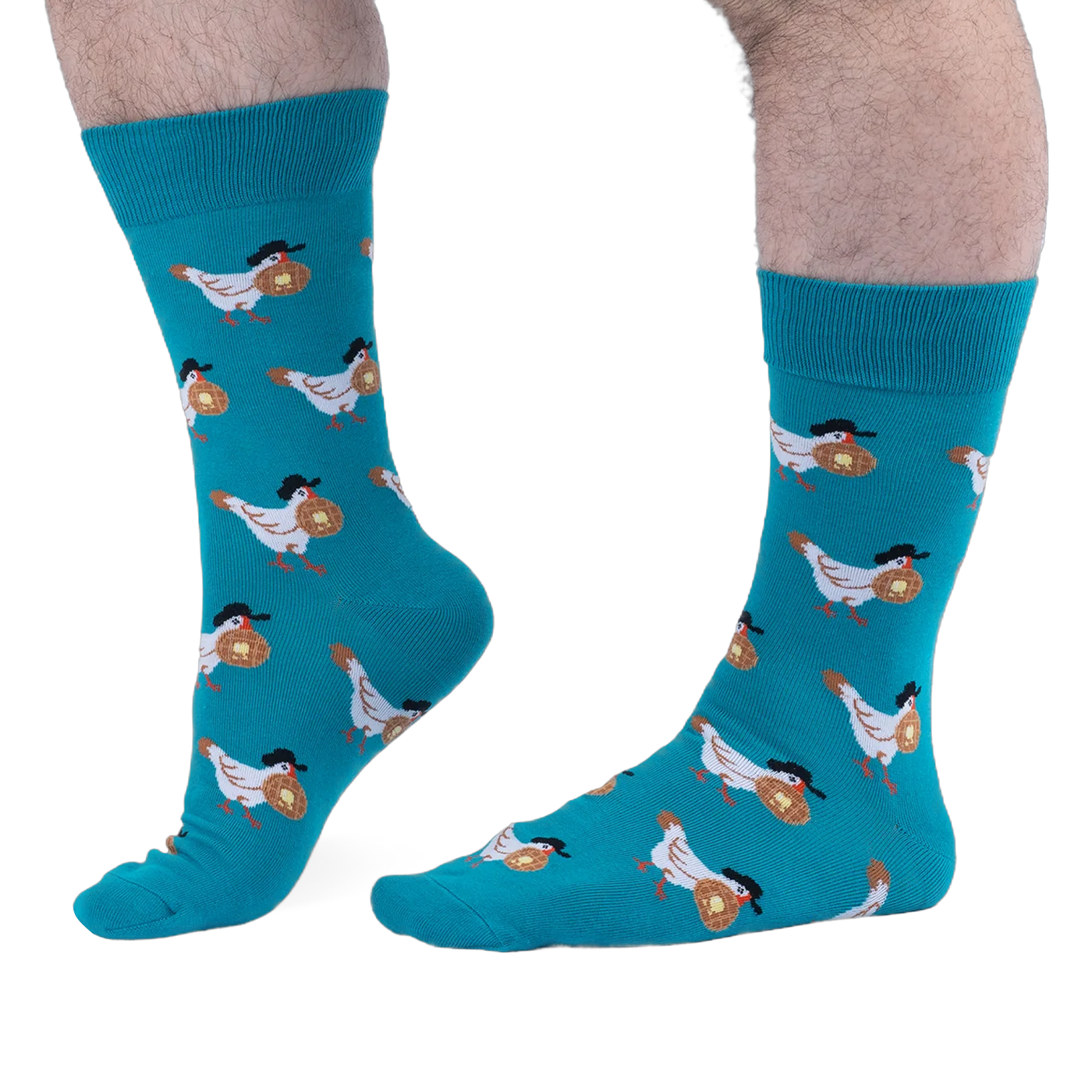 Person with hairy legs wearing bright teal crew socks that feature a pattern of white chickens carrying buttered waffles.