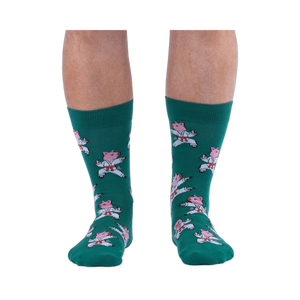 Front view of a person's lower legs wearing green socks with a pattern of pink pigs in white karate uniforms.