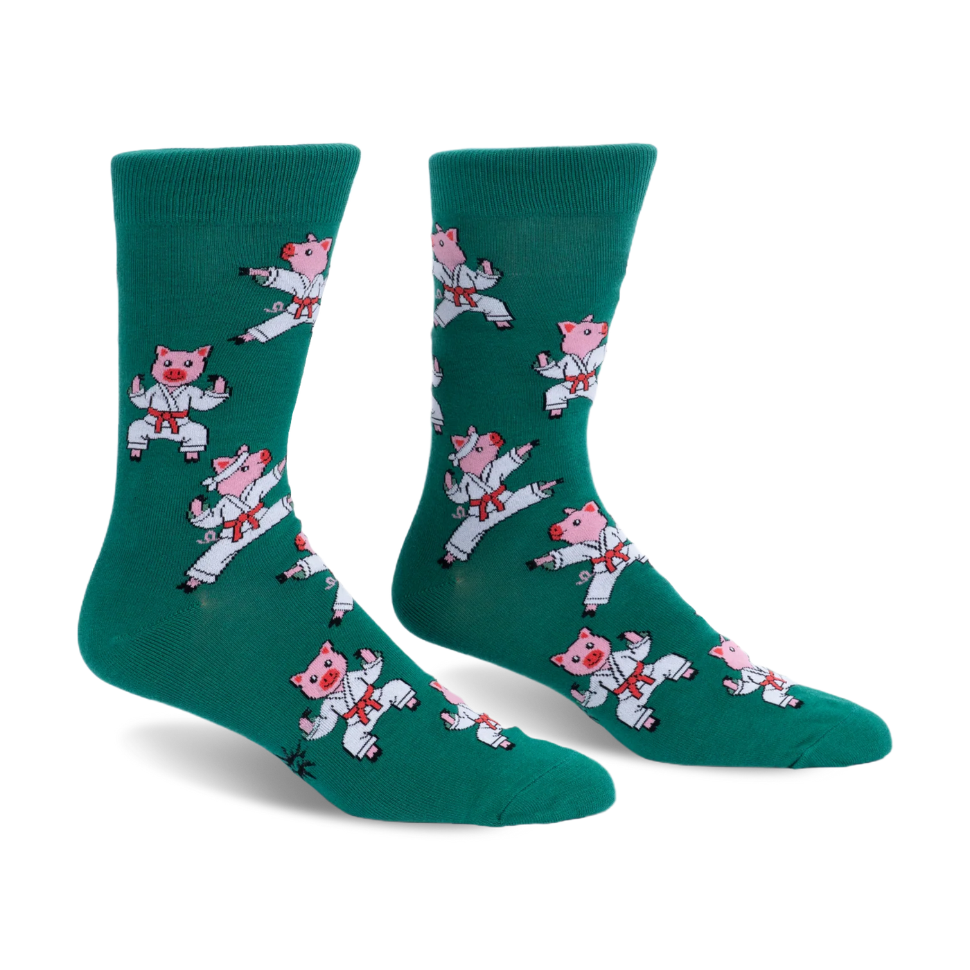 Pair of green crew socks featuring a pattern of pink pigs wearing white karate uniforms and red belts in martial arts poses.