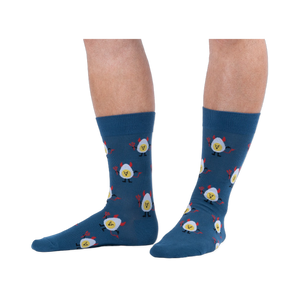 Lifestyle shot of a person wearing dark blue crew socks with a deviled egg pattern against a solid black background.