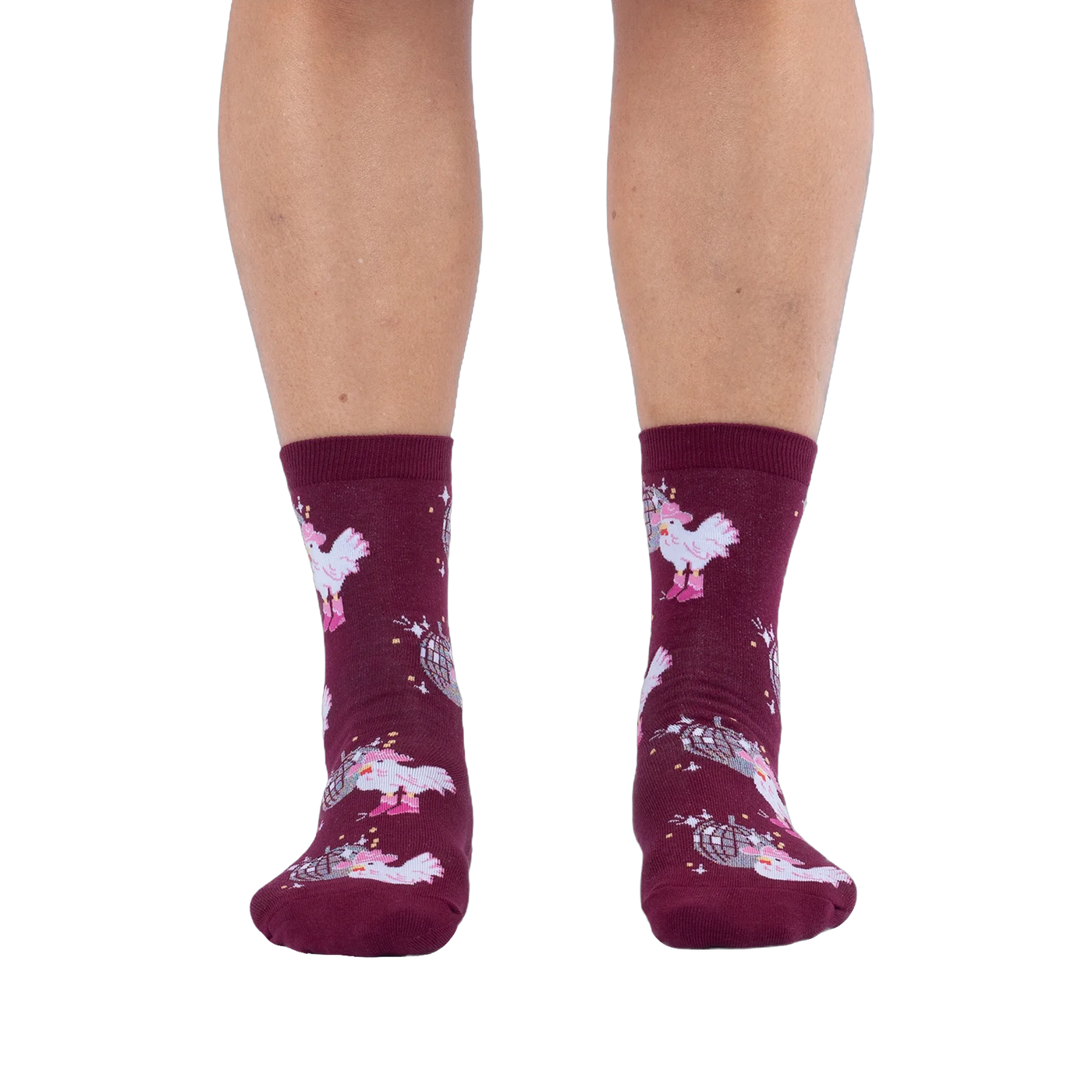 Front view of someone wearing burgundy crew socks with a disco ball and cowboy chicken pattern against a black background.