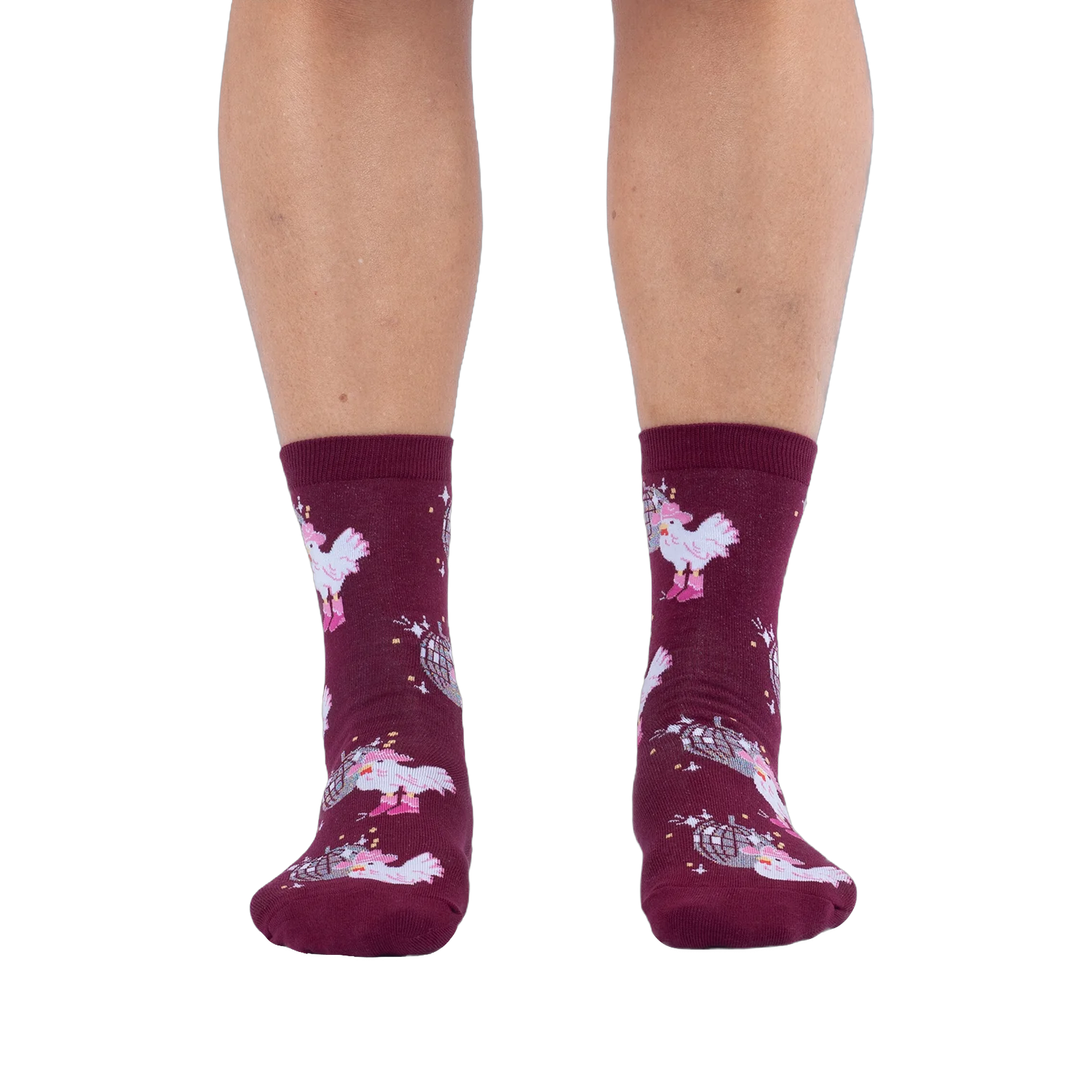 Front view of someone wearing burgundy crew socks with a disco ball and cowboy chicken pattern against a black background.