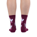 Back view of legs wearing burgundy crew socks featuring white chickens in pink boots and disco balls on a black background.
