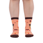 Front view of someone wearing peach mushroom socks on a dark background, showing brown toes and scattered ladybug details.