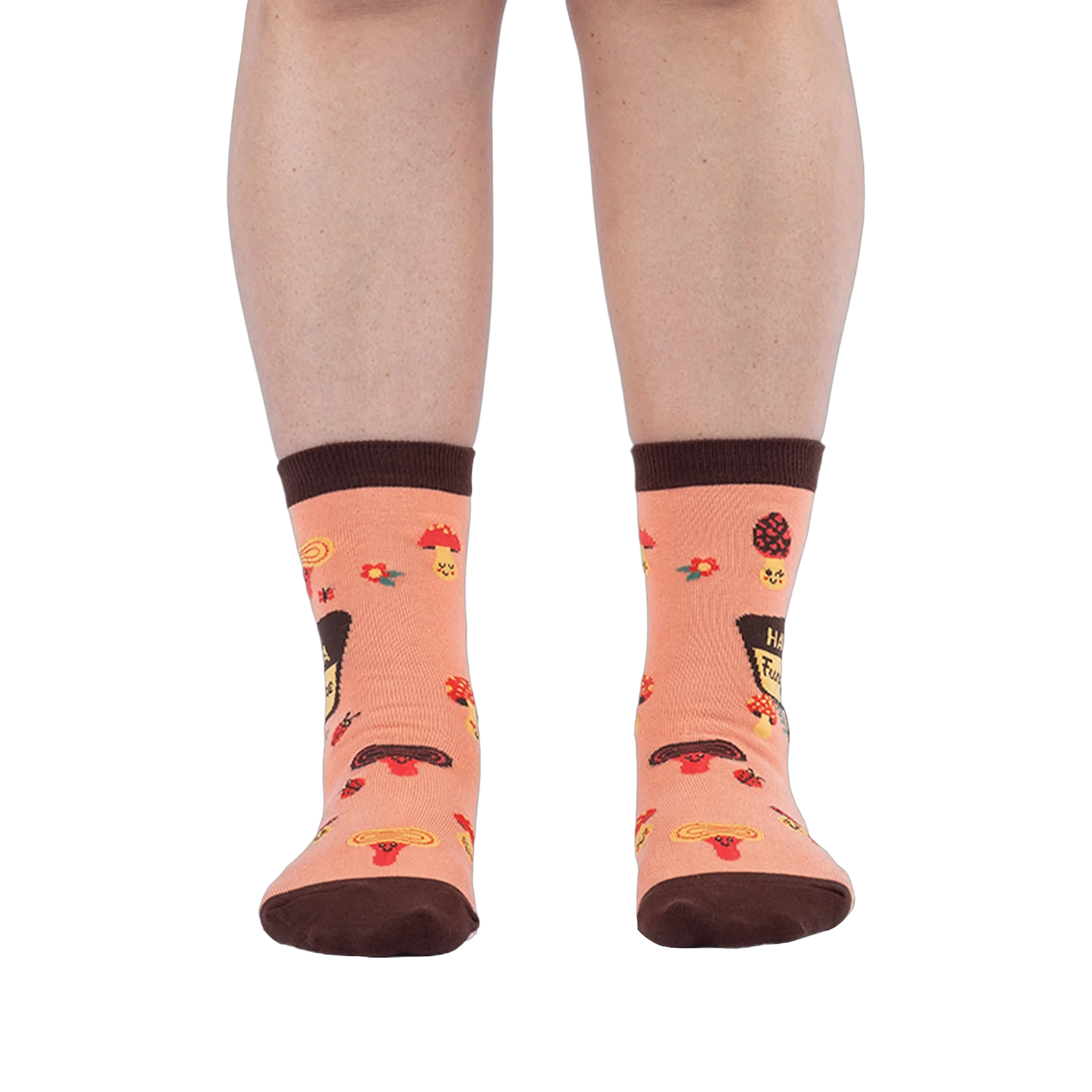 Front view of someone wearing peach mushroom socks on a dark background, showing brown toes and scattered ladybug details.