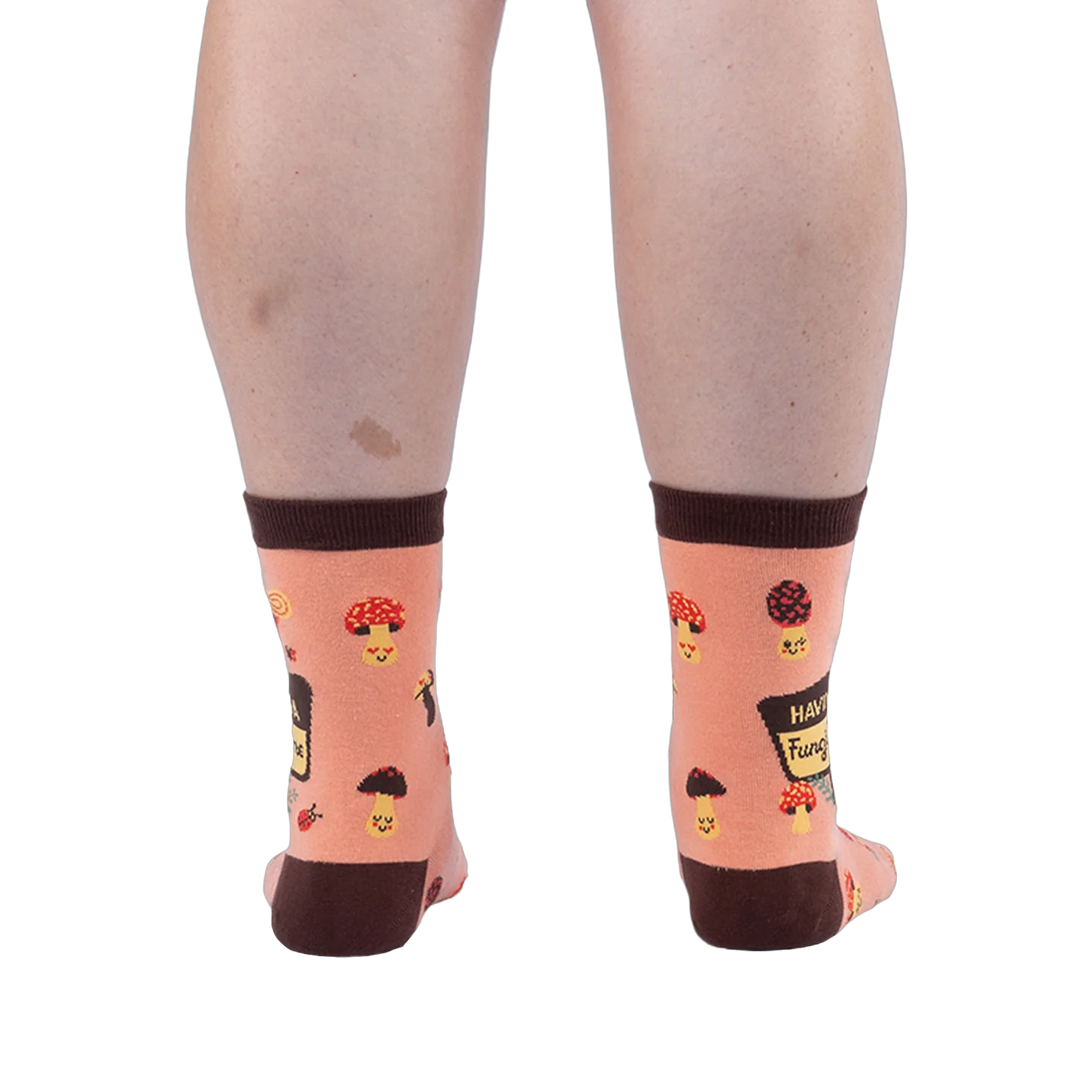 Back view of a person wearing peach mushroom socks, highlighting the dark brown heels, top cuffs, and happy mushroom pattern.