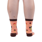 Back view of a person wearing peach mushroom socks, highlighting the dark brown heels, top cuffs, and happy mushroom pattern.