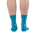 Back view of a person's calves wearing the teal ballet frog socks, showing the green frog and pink tutu design from behind.