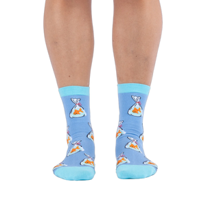 Front view of a person wearing light blue socks showing a pattern of orange goldfish in plastic bags and bright aqua cuffs.