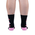Back view of legs wearing black crew socks showing a solid black calf, pink heels, wrap-around text, and graphic edges.