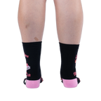 Back view of legs wearing black crew socks showing a solid black calf, pink heels, wrap-around text, and graphic edges.