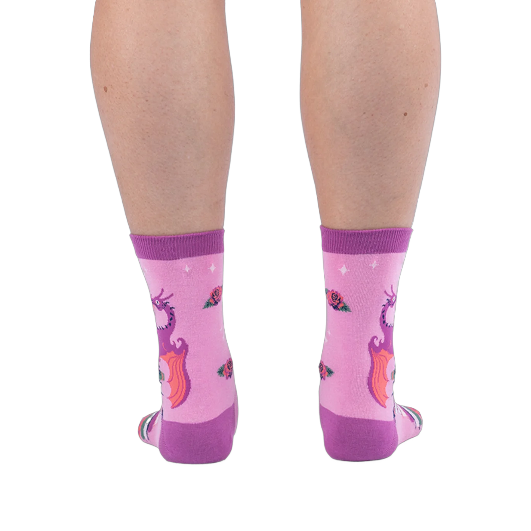 Back view of pink socks on legs, showing the back of a purple dragon with orange wings and scattered roses on the calves.
