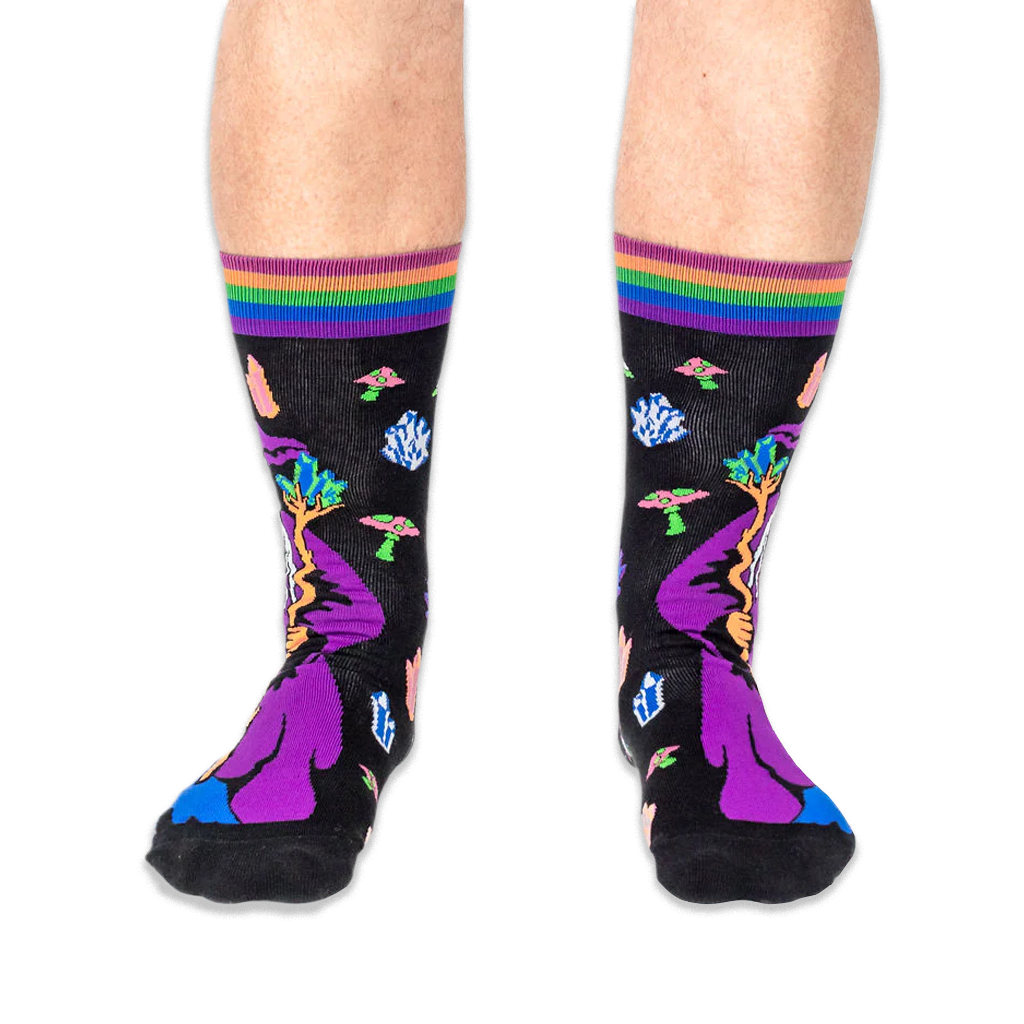 Front view of someone wearing black wizard socks, showing the wizard's purple hat, staff, and striped cuffs on both legs.