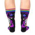 Back view of the socks being worn, displaying the back of the wizard's purple hat and glowing neon crystals on a black base.