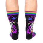 Back view of the socks being worn, displaying the back of the wizard's purple hat and glowing neon crystals on a black base.