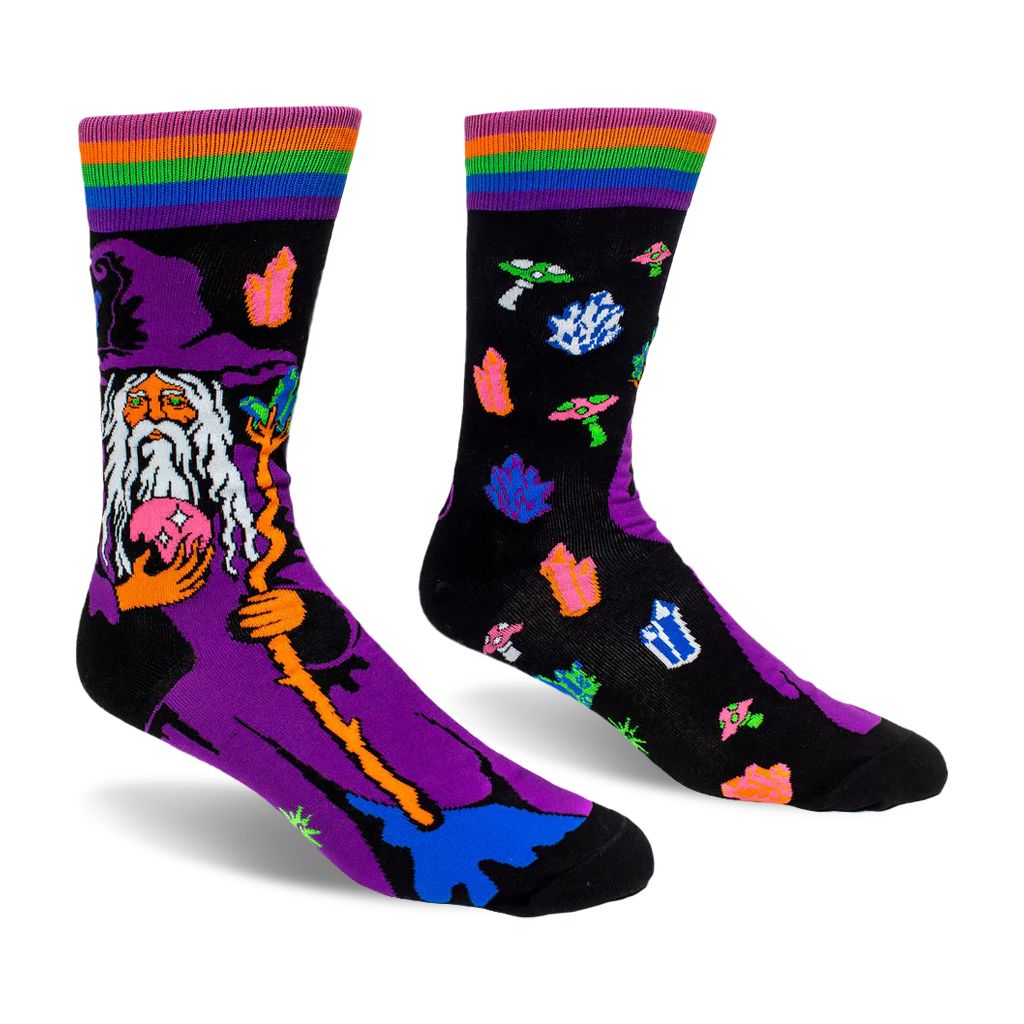 Black crew socks featuring a purple-hatted wizard holding a pink crystal ball, plus floating neon crystals and mushrooms.
