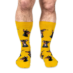 Front view of a person wearing yellow crew socks patterned with Doberman dog heads with big smiles and pink tongues.