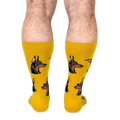 Back view of a person wearing bright yellow socks showing the profile of Doberman heads with classic black and tan markings.