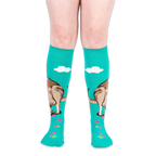 Front view of worn teal knee-high socks showing the kangaroo design wrapping around the calf and pink flowers on the feet.