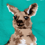 Close-up of the knit fabric showing detailed brown, tan, and white yarn creating the kangaroo face on a teal background.