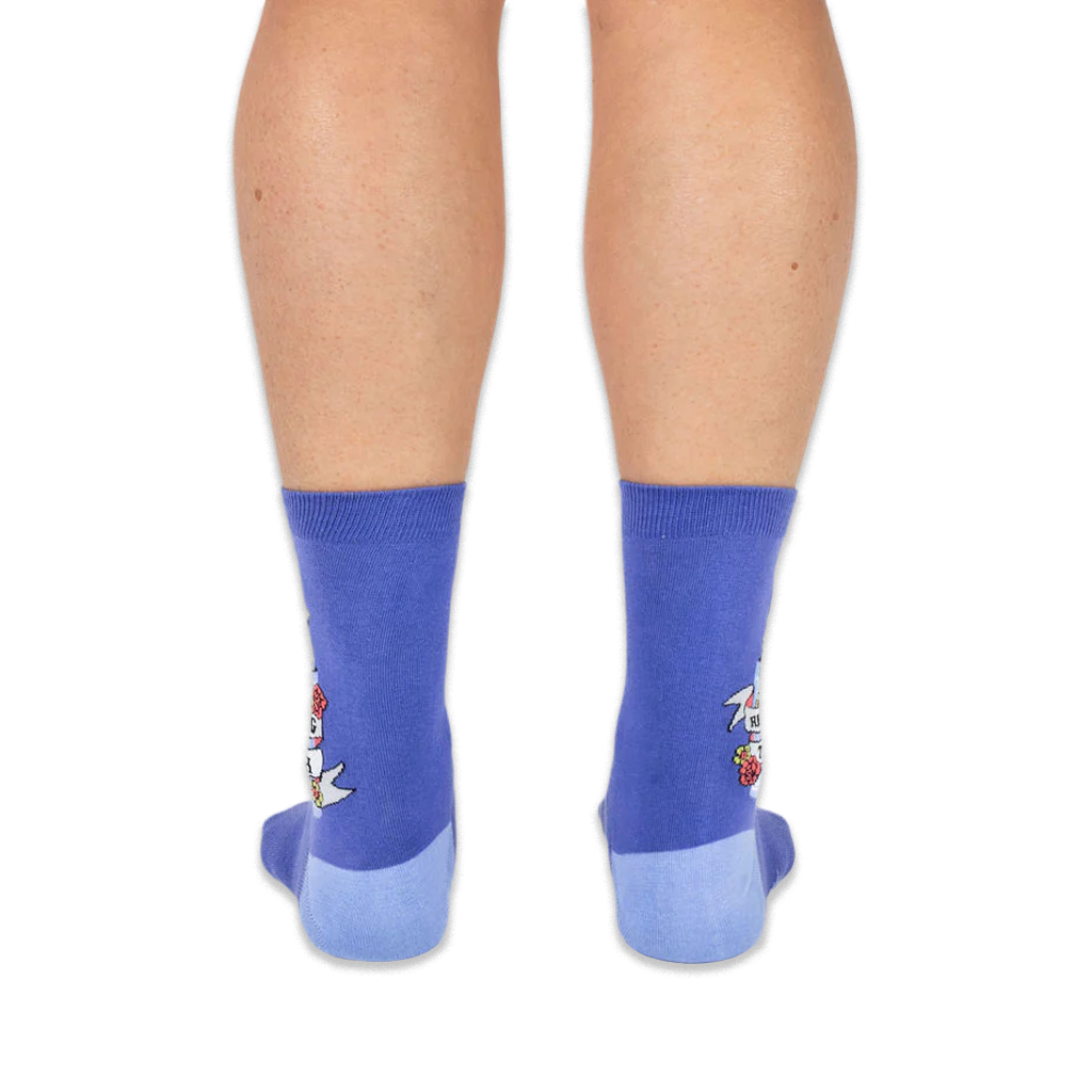 Back view of a person wearing purple crew socks with light blue heels, showing the raccoon design on the outer side edges.