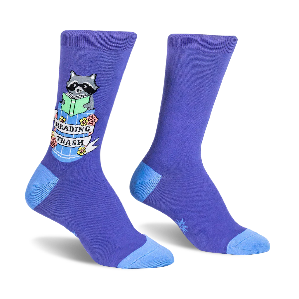 Purple crew socks featuring a raccoon reading a green book inside a trash can with a Reading Trash banner and floral details.