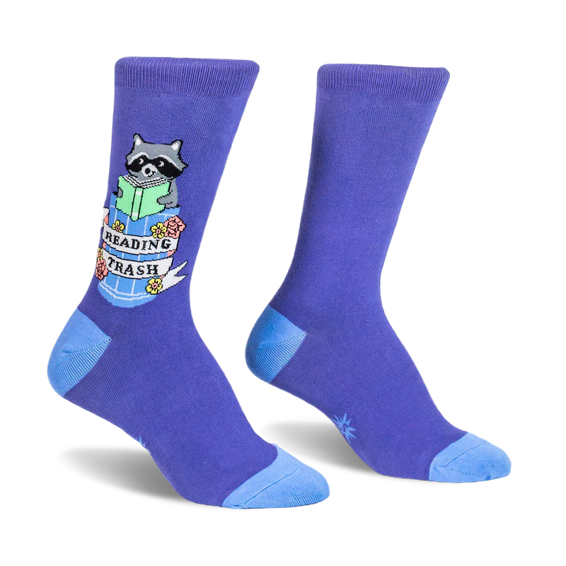 Purple crew socks featuring a raccoon reading a green book inside a trash can with a Reading Trash banner and floral details.