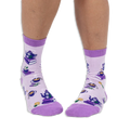 Front view of a person wearing light purple crew socks showing a pattern of teapots on books and steaming cups of tea.