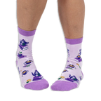 Front view of a person wearing light purple crew socks showing a pattern of teapots on books and steaming cups of tea.