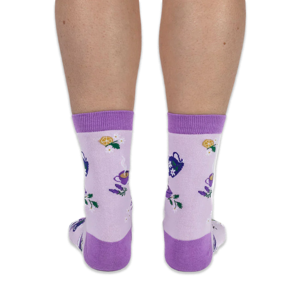 Back view of a person wearing light purple crew socks, highlighting the dark purple heel and lemon slice knit pattern.