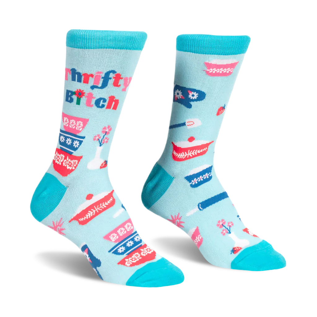 Light blue crew socks with teal trim featuring retro patterned mixing bowls, baking tools, and Thrifty B*tch text.