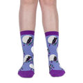 Front view of legs wearing light blue crew socks with black owls and white full moons against a solid black background.
