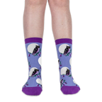 Front view of legs wearing light blue crew socks with black owls and white full moons against a solid black background.