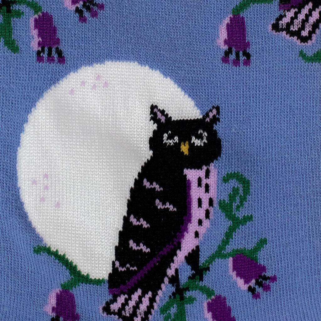 Close-up of the sock fabric showing a sleepy black owl perched on a green branch in front of a white full moon.