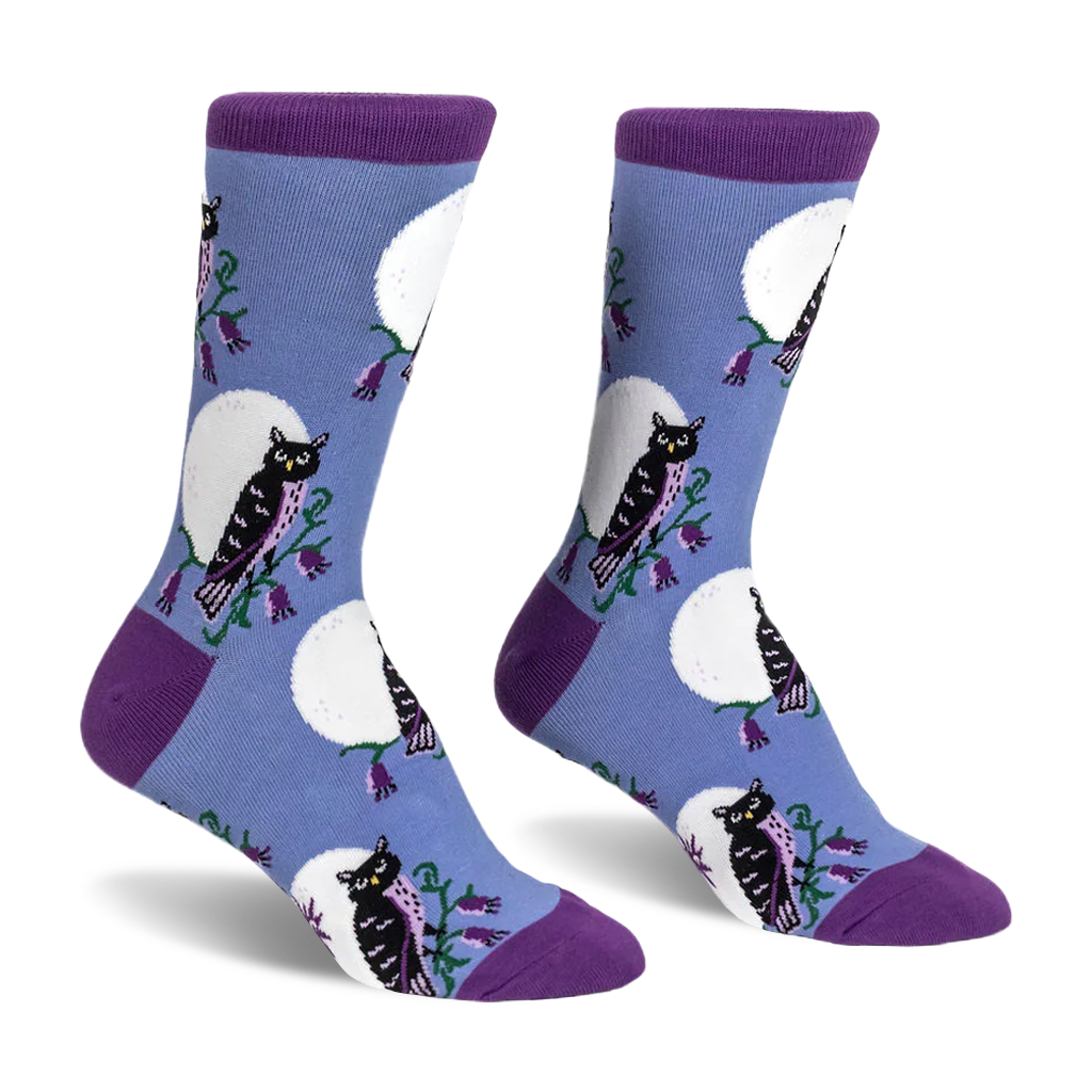 Crew socks featuring black owls, white full moons, and purple flowers on a light blue background with dark purple accents.