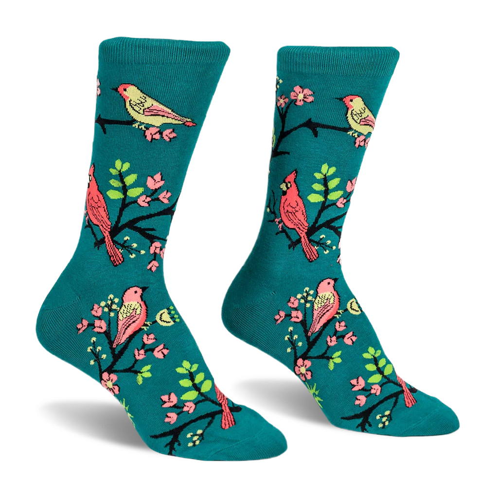 Teal crew socks featuring a pattern of red cardinals and yellow birds perched on black branches with bright pink flowers.