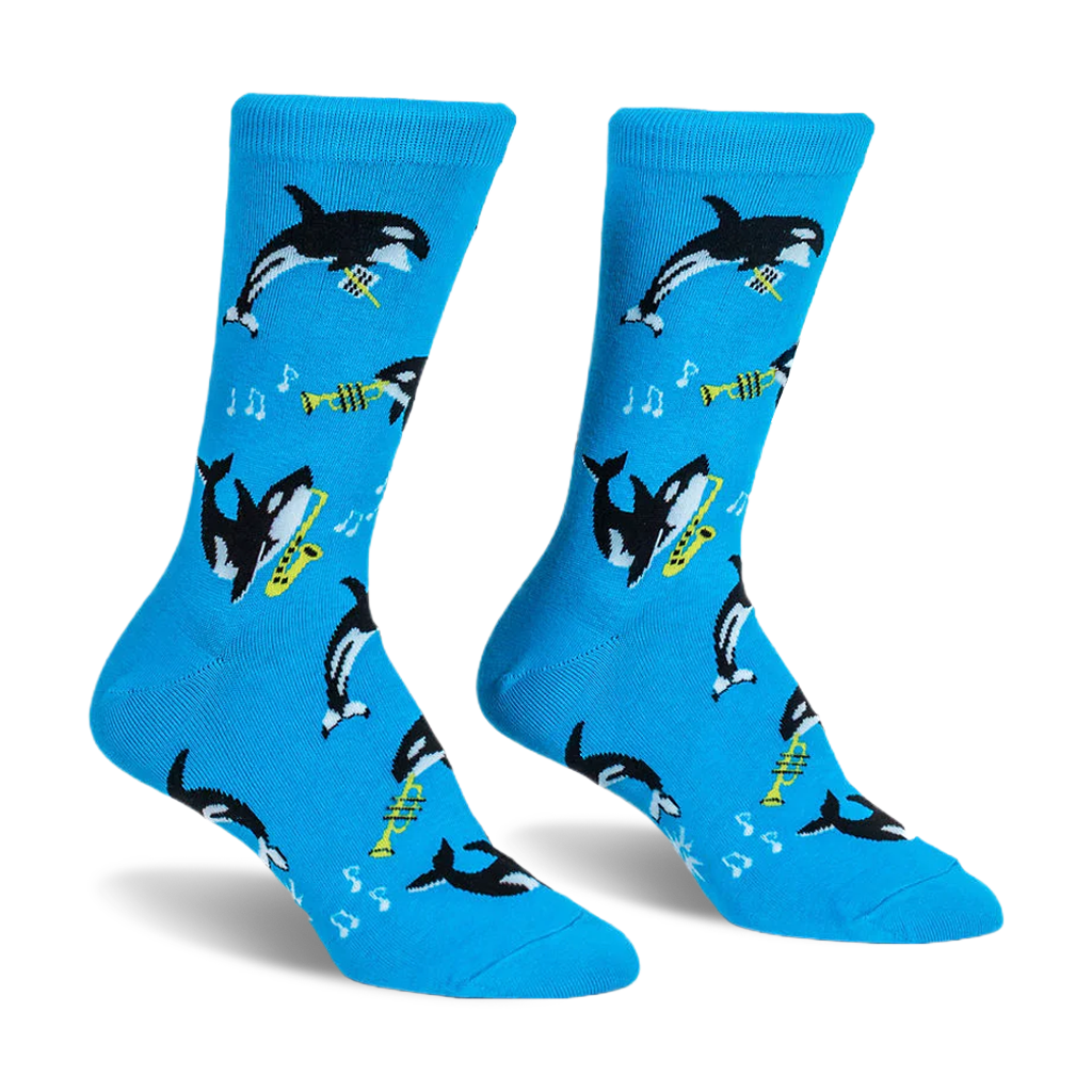 Bright blue crew socks displaying a pattern of black and white orcas playing yellow saxophones and trumpets with music notes.