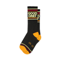A folded pair of black crew socks featuring 'Good Grief' text, orange toe and heel, and burgundy, gold, and cream stripes.